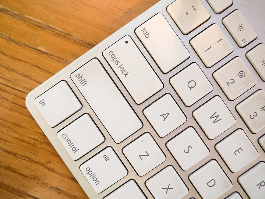Close-up of white computer keyboard on wooden desk