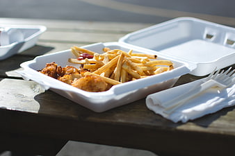 Fish and chips takeaway on wooden table outdoors