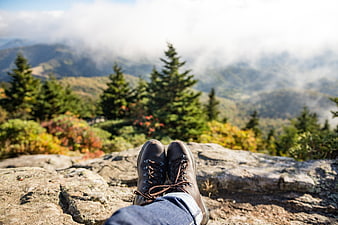 Hiker Boots on Mountain Summit with Foggy Forest View