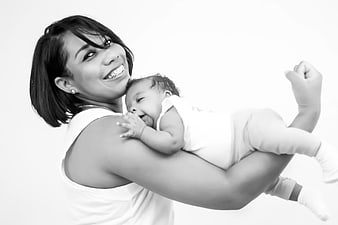 Black and white portrait of a smiling mother holding a happy baby