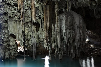 Stalactites Hanging Over Turquoise Water In Underground Cavern