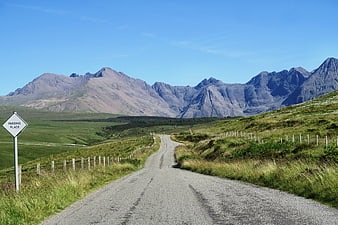 Winding Highland Road Leading to Majestic Mountains