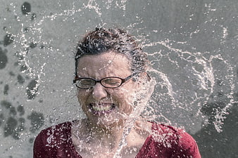 Woman with glasses getting splashed by water