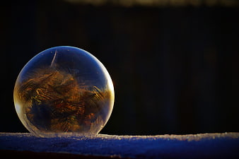 Frozen Soap Bubble with Intricate Ice Crystals on Snow
