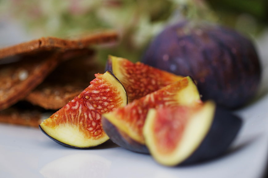 Fresh Sliced Figs and Whole Fruit on White Plate