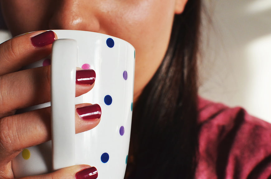 Close-up of Woman Drinking from Polka Dot Mug