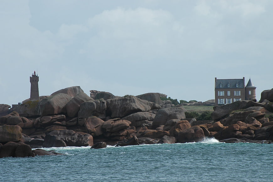 Lighthouse and house on rocky coast in Brittany, France