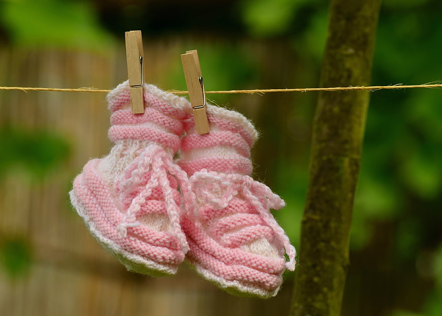 Pink Knitted Baby Booties Hanging on Clothesline