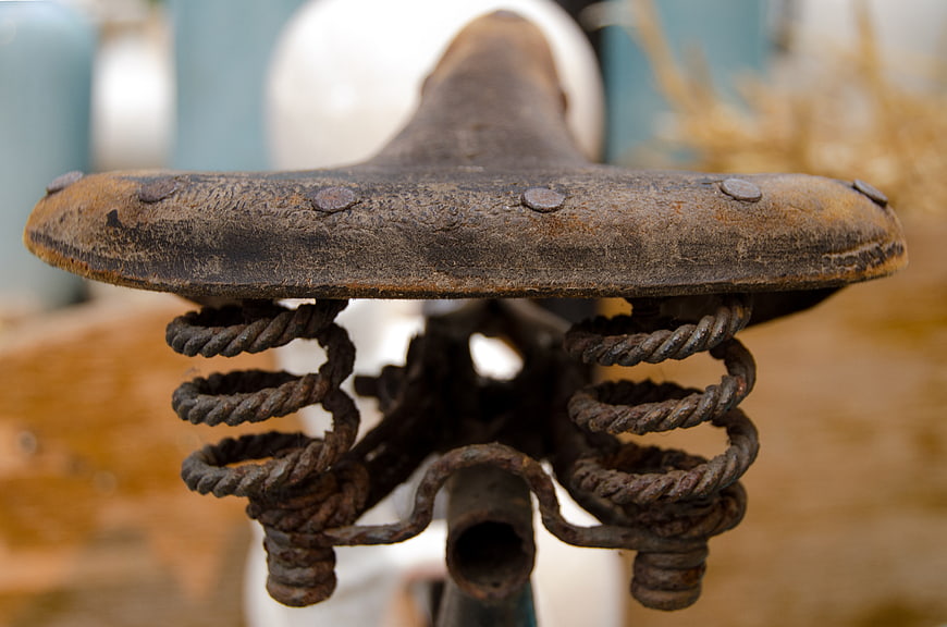Close-up of rusty vintage bicycle saddle with springs