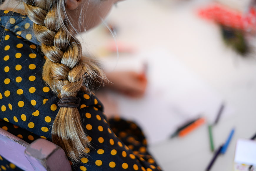 Close-up of child's braid and polka dot dress
