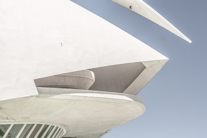 Low angle view of modern white concrete architecture against blue sky