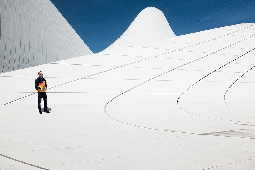 Man standing on white curved modern architecture rooftop