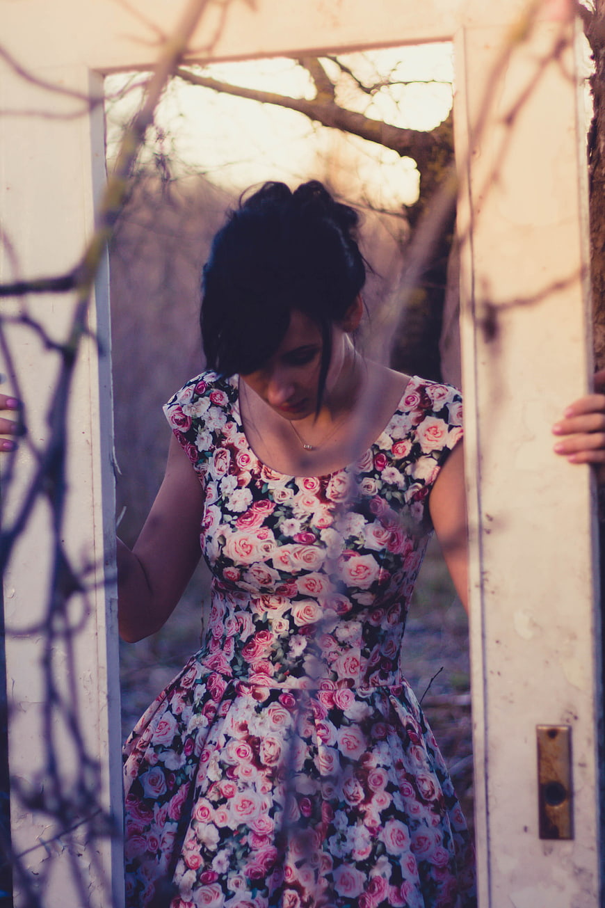 Woman in Floral Dress Standing in Doorway