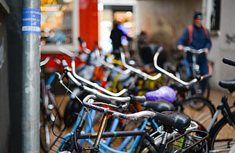 Row of parked bicycles on a rainy city street