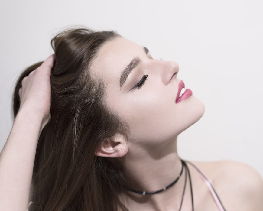 Close-up portrait of beautiful woman with hand in hair
