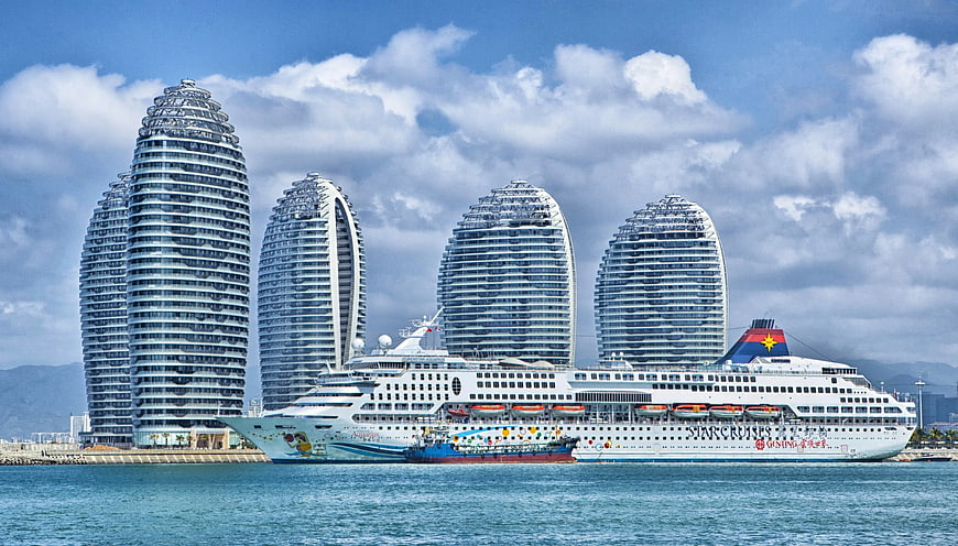 White Cruise Ship Docked Near Iconic Sanya Phoenix Island Towers
