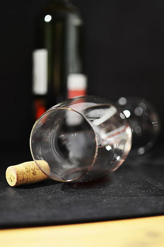 Tilted Empty Wine Glass with Cork on Dark Background