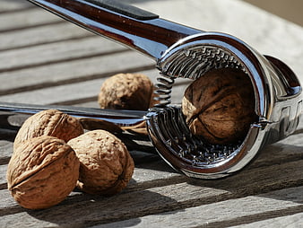 Walnuts and metal nutcracker on rustic wooden table