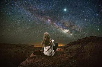 Woman Sitting On Rock Under Milky Way Night Sky