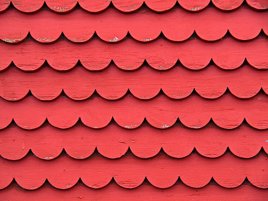 Red scalloped wooden roof shingles texture pattern