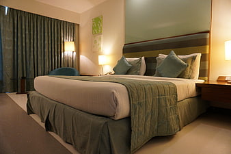 Modern Hotel Bedroom Interior with Green Bedding and Warm Lighting