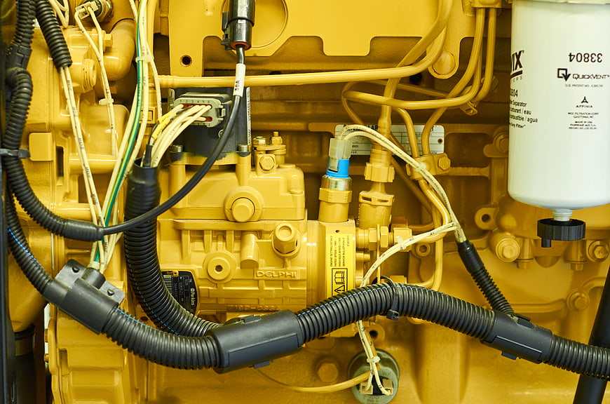 Close-up of yellow diesel generator engine with wires and filter