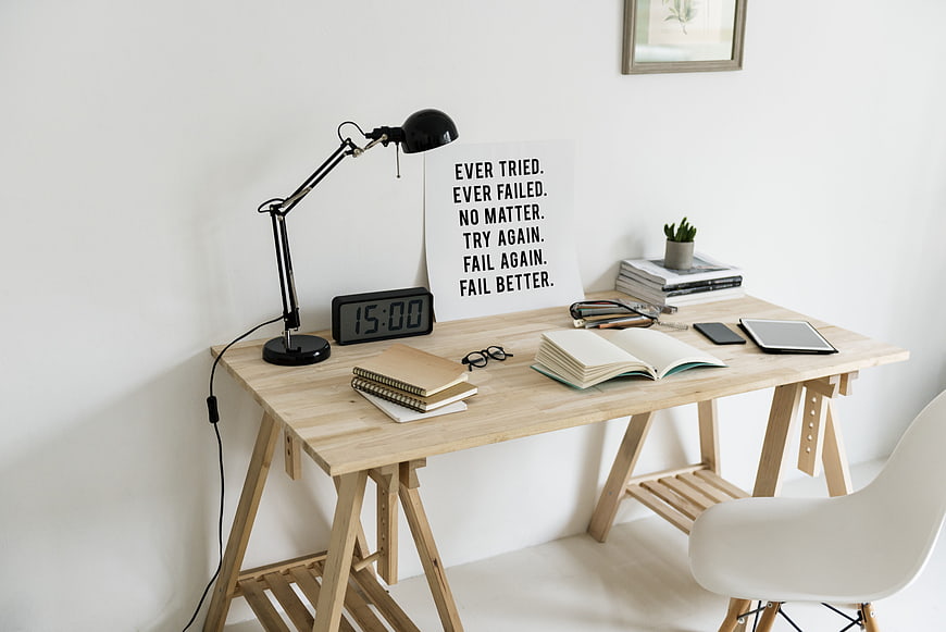Minimalist wooden workspace with motivational quote and office supplies