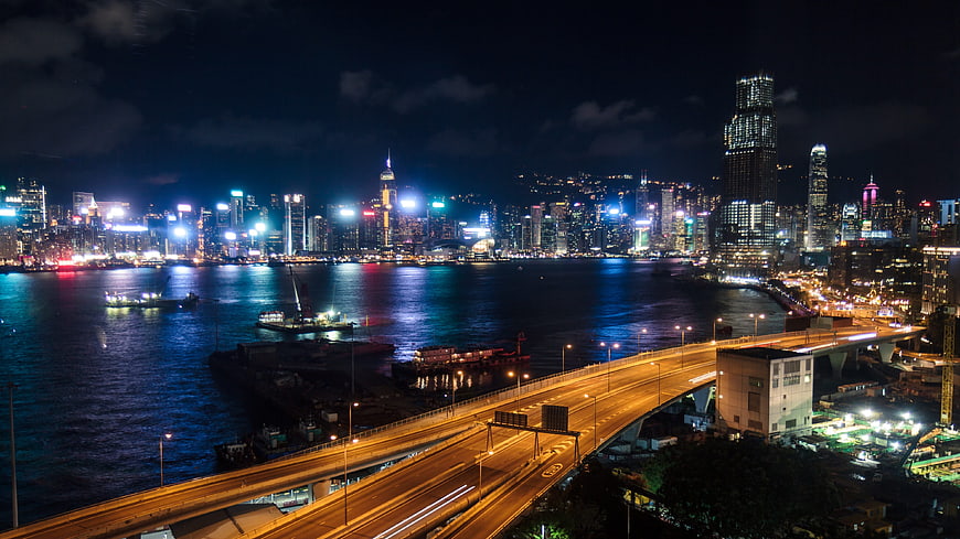 Hong Kong skyline at night with Victoria Harbour and highway