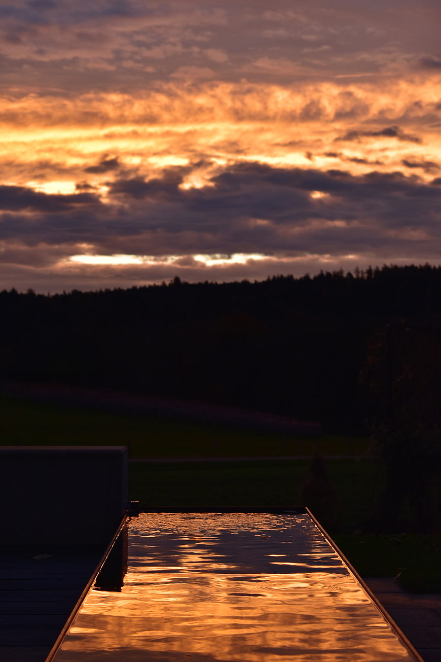 Golden sunset reflection on modern rectangular pool