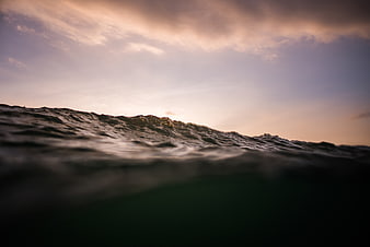 Dramatic Ocean Waves at Sunset with Soft Sky