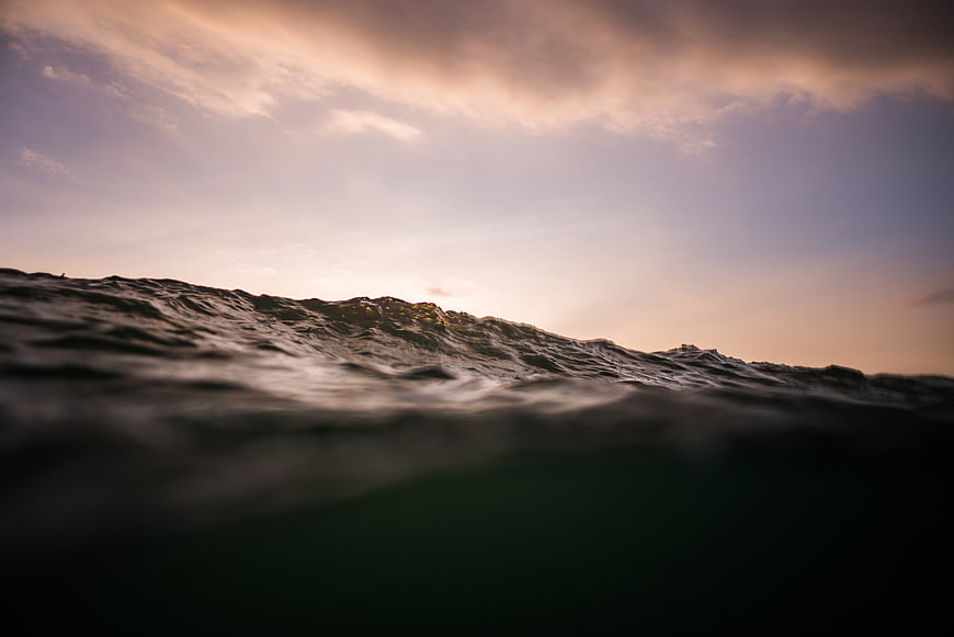 Dramatic Ocean Waves at Sunset with Soft Sky