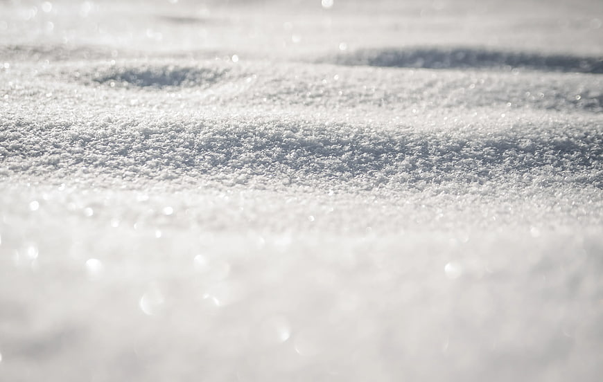Close-up of sparkling snow texture with bokeh background