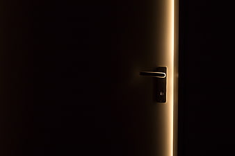 Modern door handle with warm light strip in dark room