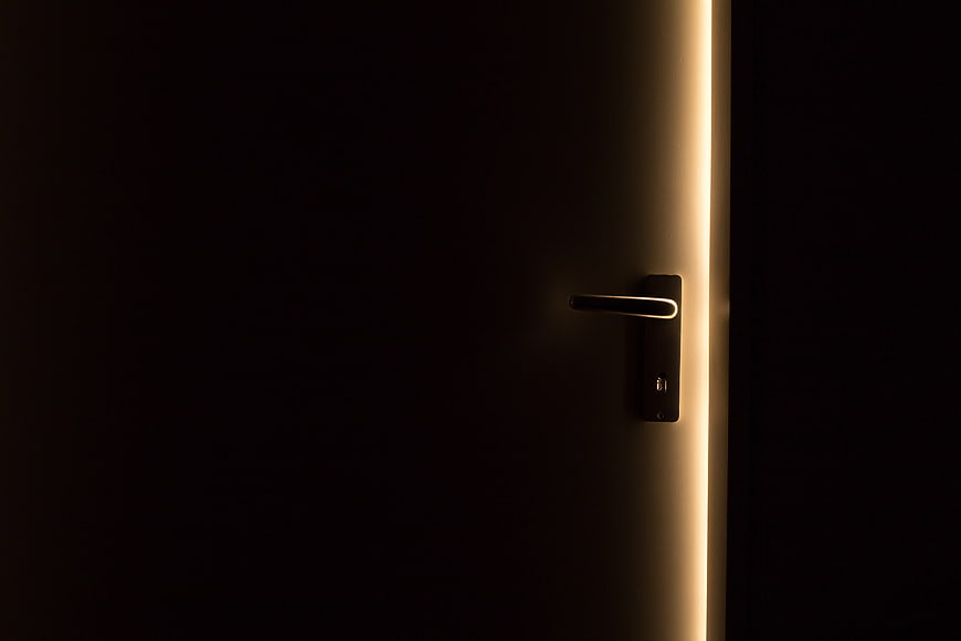 Modern door handle with warm light strip in dark room