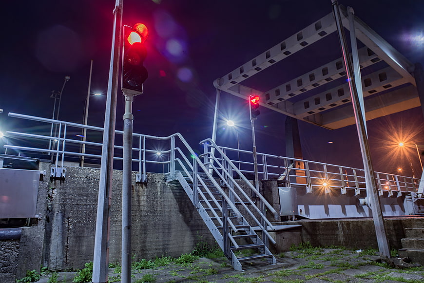 Red Traffic Light on Industrial Bridge at Night