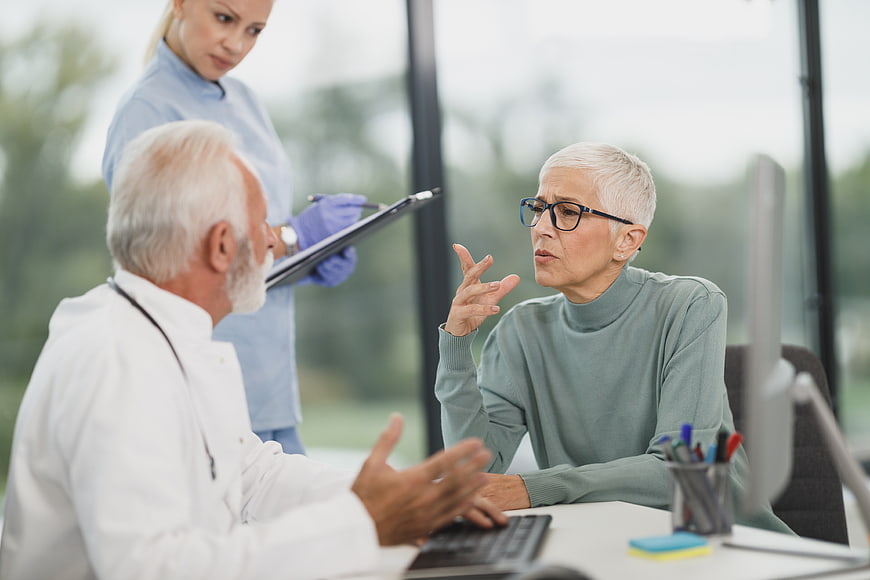 Senior doctor consulting with elderly female patient in clinic