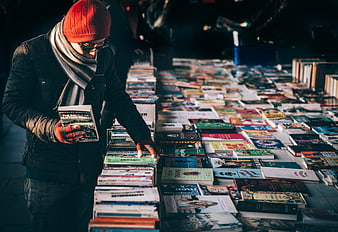 Man browsing books at outdoor market stall