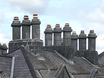 Old stone chimneys on a slate roof in Ireland