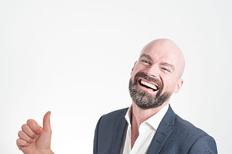 Happy bald businessman in suit giving thumbs up on white background