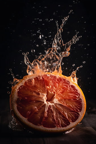 Fresh Grapefruit Slice with Water Splash on Dark Background