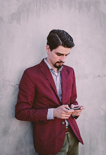 Man in Red Blazer Texting on Smartphone Against Concrete Wall