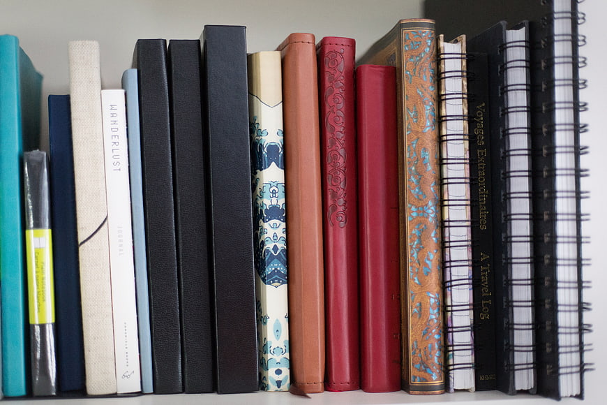 Colorful Books and Notebooks on a White Shelf