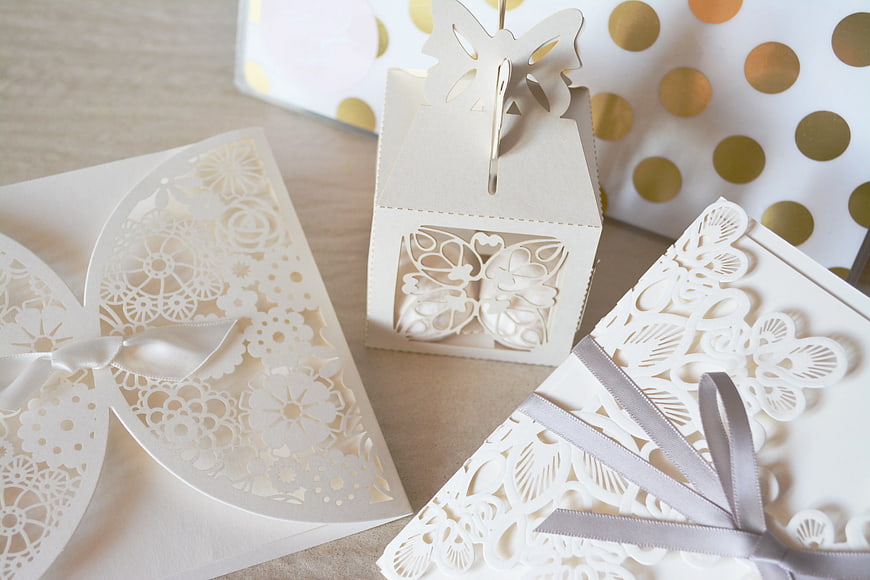 White laser-cut paper gift boxes with gold polka dots