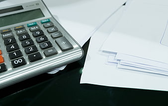 Close-up of calculator and documents on office desk