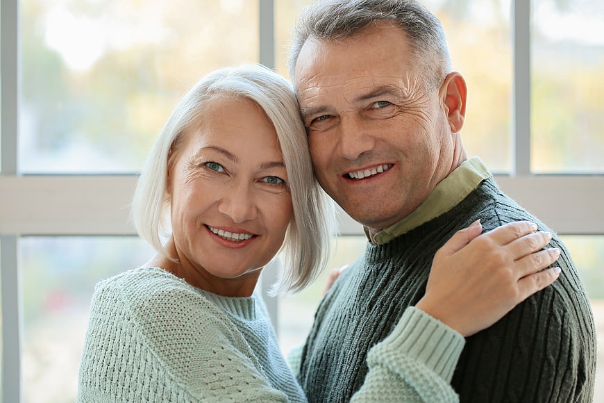 Happy Senior Couple Smiling and Embracing Indoors
