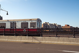 Silver and red commuter train crossing a bridge in a city