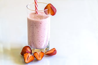 Fresh Strawberry Smoothie in Glass with Straw and Fruit