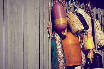Colorful Fishing Buoys Hanging on Weathered Wooden Wall