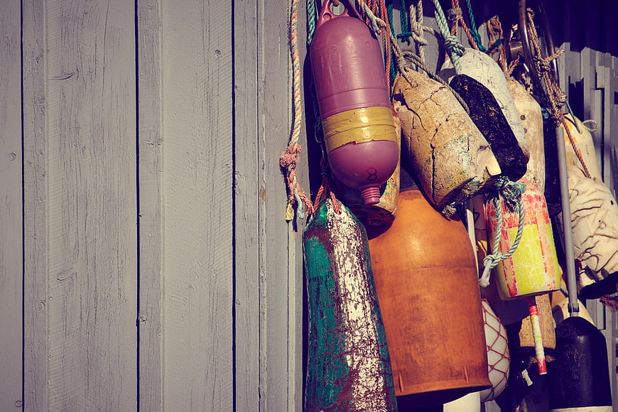 Colorful Fishing Buoys Hanging on Weathered Wooden Wall