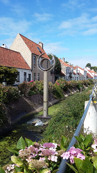 Modern Sculpture in Canal with Traditional Flemish Houses